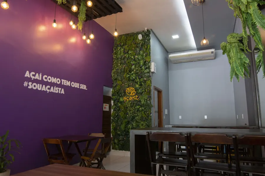 Parede roxa da loja Açaíst com a frase Açaí como tem que ser