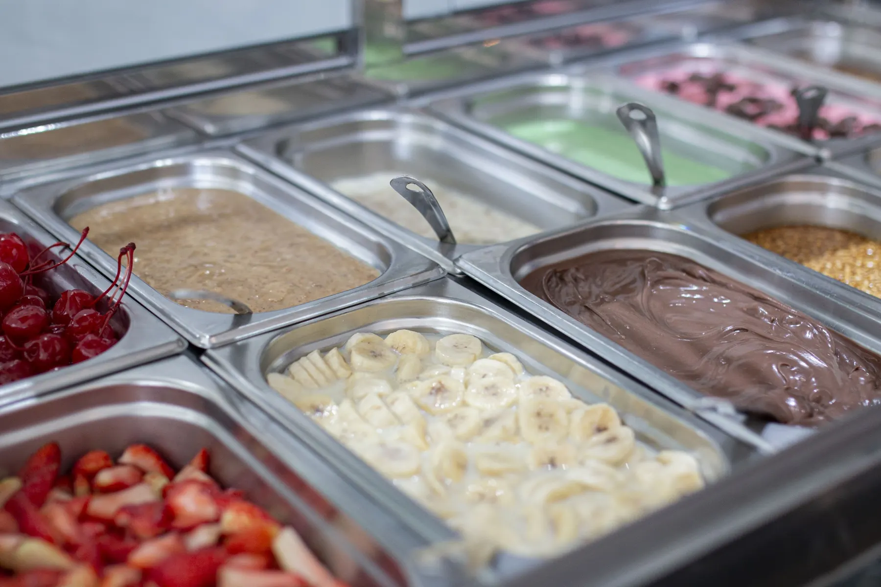 Cubas de açaí, cremes e frutas no balcão de uma loja Açaíst